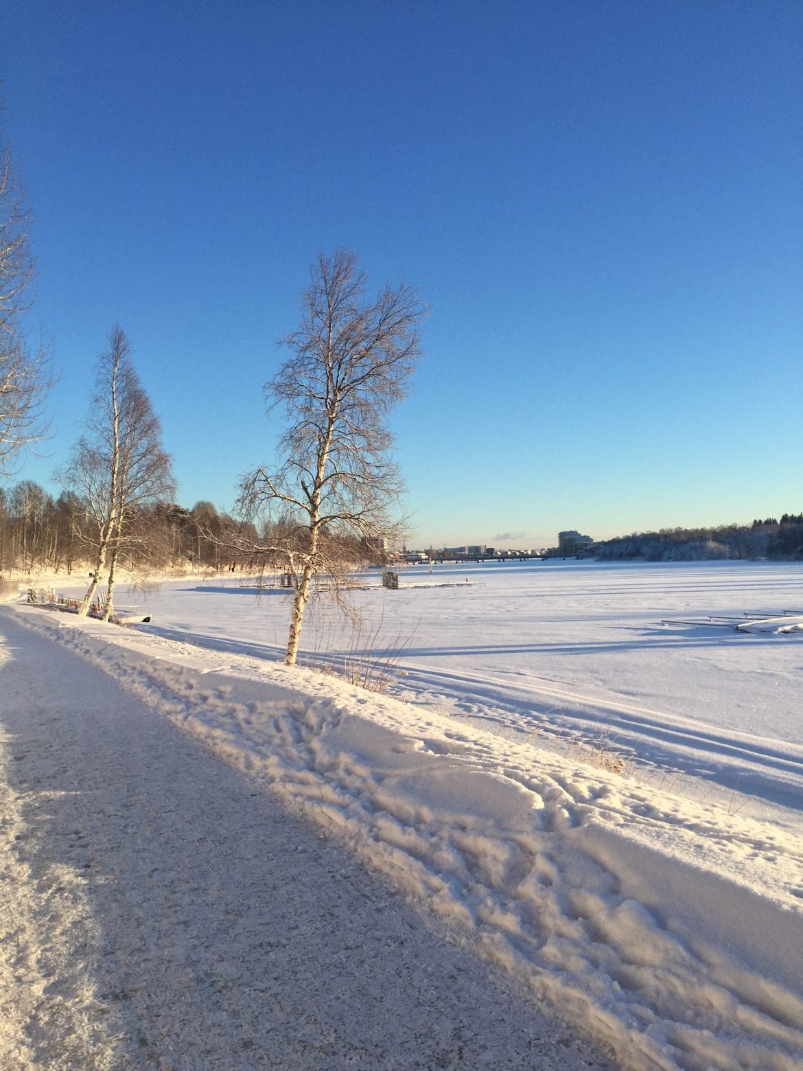 Vacker promenad med sol, blå himmel och vitt på marken