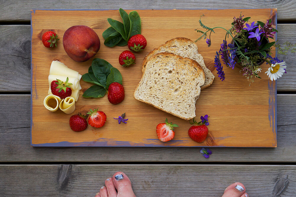 frukostbricka med rostat bröd, ost och jordgubbar